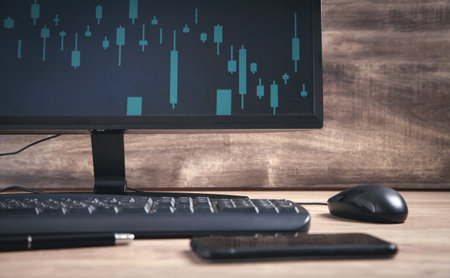 Black computer with keyboard and mouse on the table. Charts on screen. analysis. business