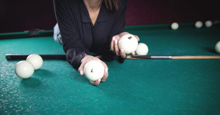 Woman holding billiard balls on the table.