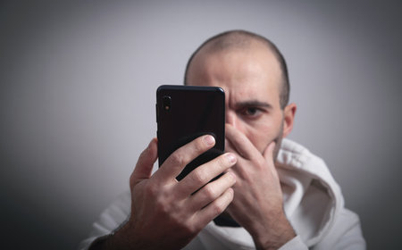 Man looking at mobile phone screen. Social Media Addiction