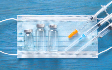 Syringes, mask and vials on the blue background.の写真素材