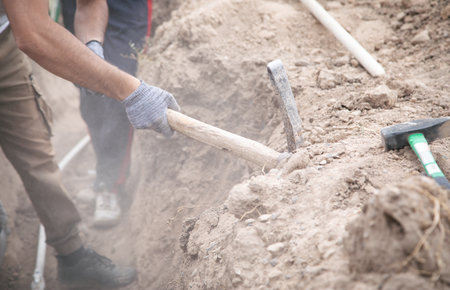 Caucasian worker digging a hole.