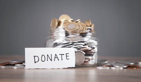 Glass jar with coins and Donate word.の写真素材