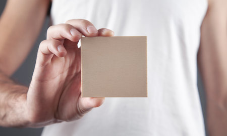 Male hand holding wooden empty board for your text.の写真素材