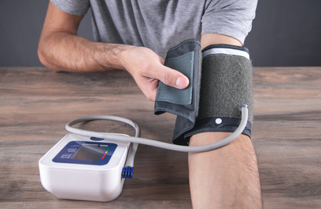 Caucasian man measuring his blood pressure at home.