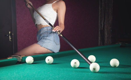 Caucasian young girl playing billiards.