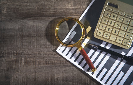 Pen, calculator, magnifying glass on financial graphs.の写真素材