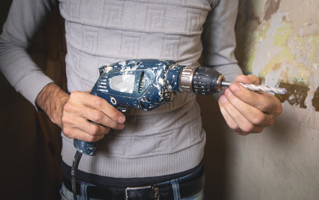 Man holds a drill. Doing home renovationの写真素材