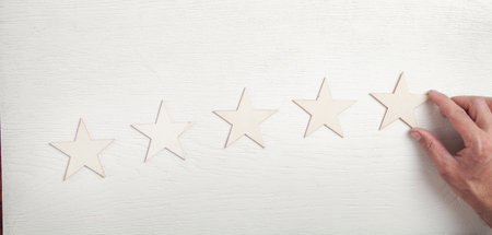 Male hand showing five star rating. Customer service experience and satisfaction