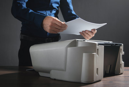 Man copying and scanning documents in office.