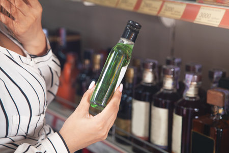 Woman buying vodka at supermarket.の写真素材