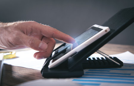 Male hand touching in white digital tablet screen.