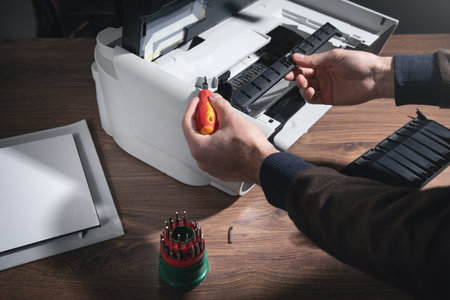 Caucasian man repairing digital printer.の写真素材