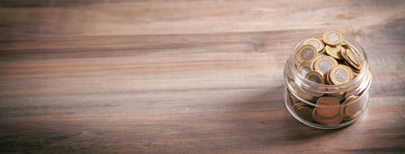 Jar of coins on wooden background.の写真素材