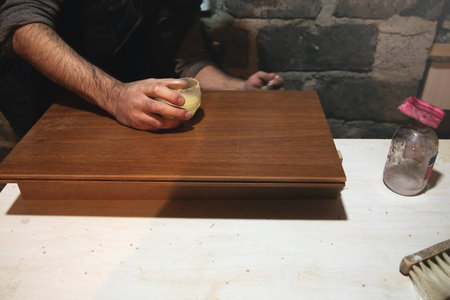 Carpenter varnishing wood for modern furniture.の写真素材