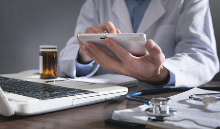 Doctor using white digital tablet.