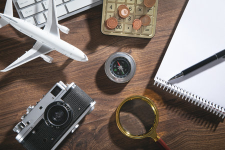 Calculator, coins, retro camera, airplane on the wooden background.の写真素材