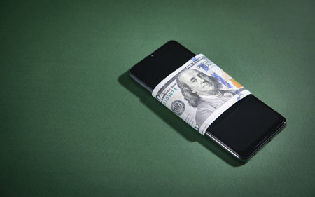 Smartphone and money on green background.の写真素材