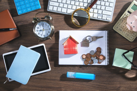Coins, house model and keys with a business object.の写真素材
