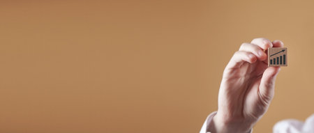 Male hand showing growth graph on wooden cube.の写真素材