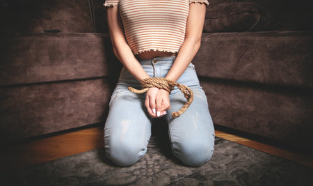 Hands of a victim woman tied with rope.の写真素材
