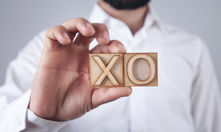 Man holding wooden X, O symbols.の写真素材