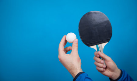Man holding tennis racket and white plastic ball.の写真素材