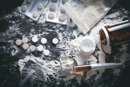 Heroin powder, pills and syringe on the dark background.の写真素材