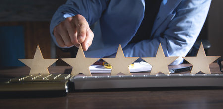 Male hand showing five star rating.