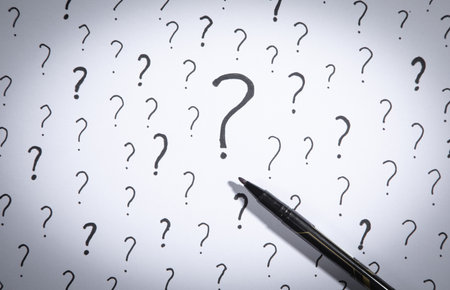 Question marks and marker on white background.