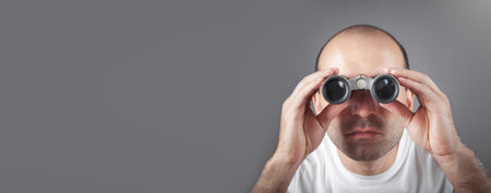Man with binoculars looking into the distance.の写真素材