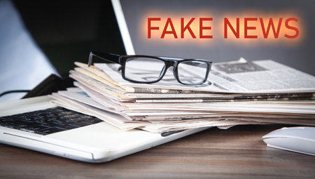 fake news. Newspapers, eyeglasses, laptop computer.