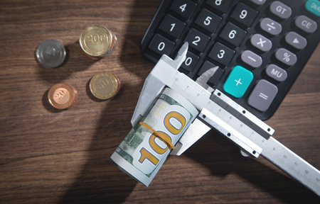 Caliper with a coin, money and calculator.の写真素材