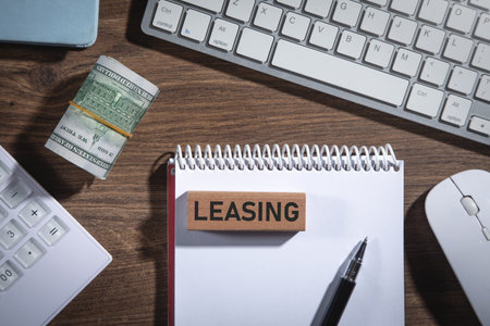 Leasing word on wooden block with a calculator and money.