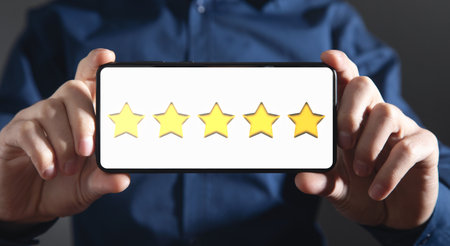 Male hand showing 5 stars on smartphone screen.