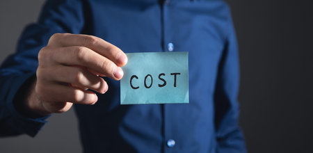 Businessman showing Cost text on sticky note.