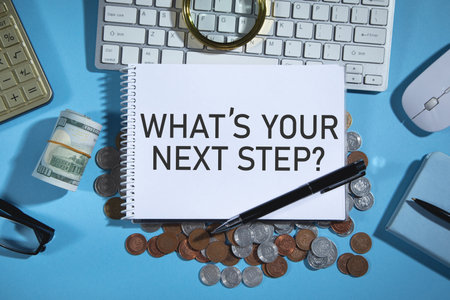 What's Your Next Step? on notepad with a money and business objects.