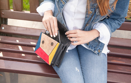 Young woman putting mobile phone to her bag.の写真素材