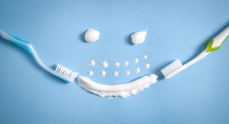 Toothbrush and toothpaste on the blue background. smiling face