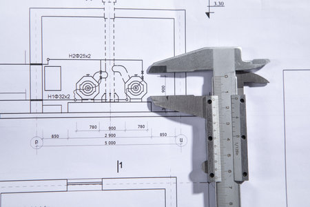 Caliper on engineering drawing blueprint.
