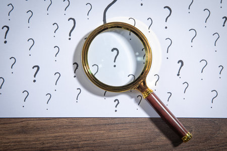 Magnifying glass and question mark on white background.
