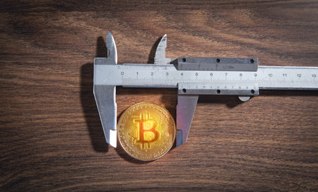 Vernier caliper and Bitcoin on the wooden table.の写真素材