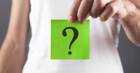Man showing question mark on sticky note.