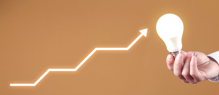 Male hand showing light bulb with a growing arrows. ideas. creativityの写真素材
