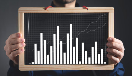 Man showing business graph on blackboard.