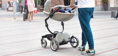 Father walking in city baby in stroller.