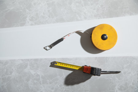 Measure tape on ceiling plastic panel.