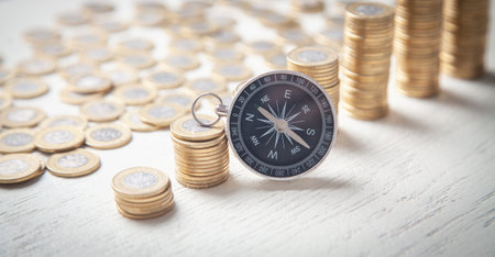 Compass and coins on the white desk.の写真素材