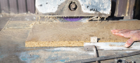 electric tile cutter. Tiler cutting tile on wet saw machine