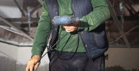Man holds a drill. Doing home renovation