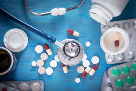 Stethoscope and various pills on the blue background.の写真素材